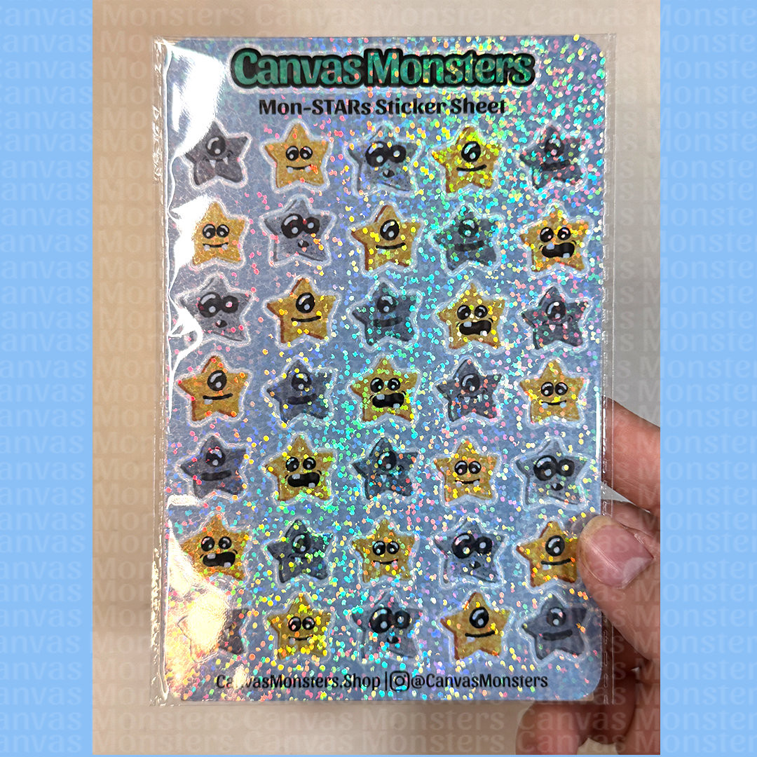 Sheet of star-shaped stickers with faces on a blue background branded 'Canvas Monsters', held by a hand against a beige background.