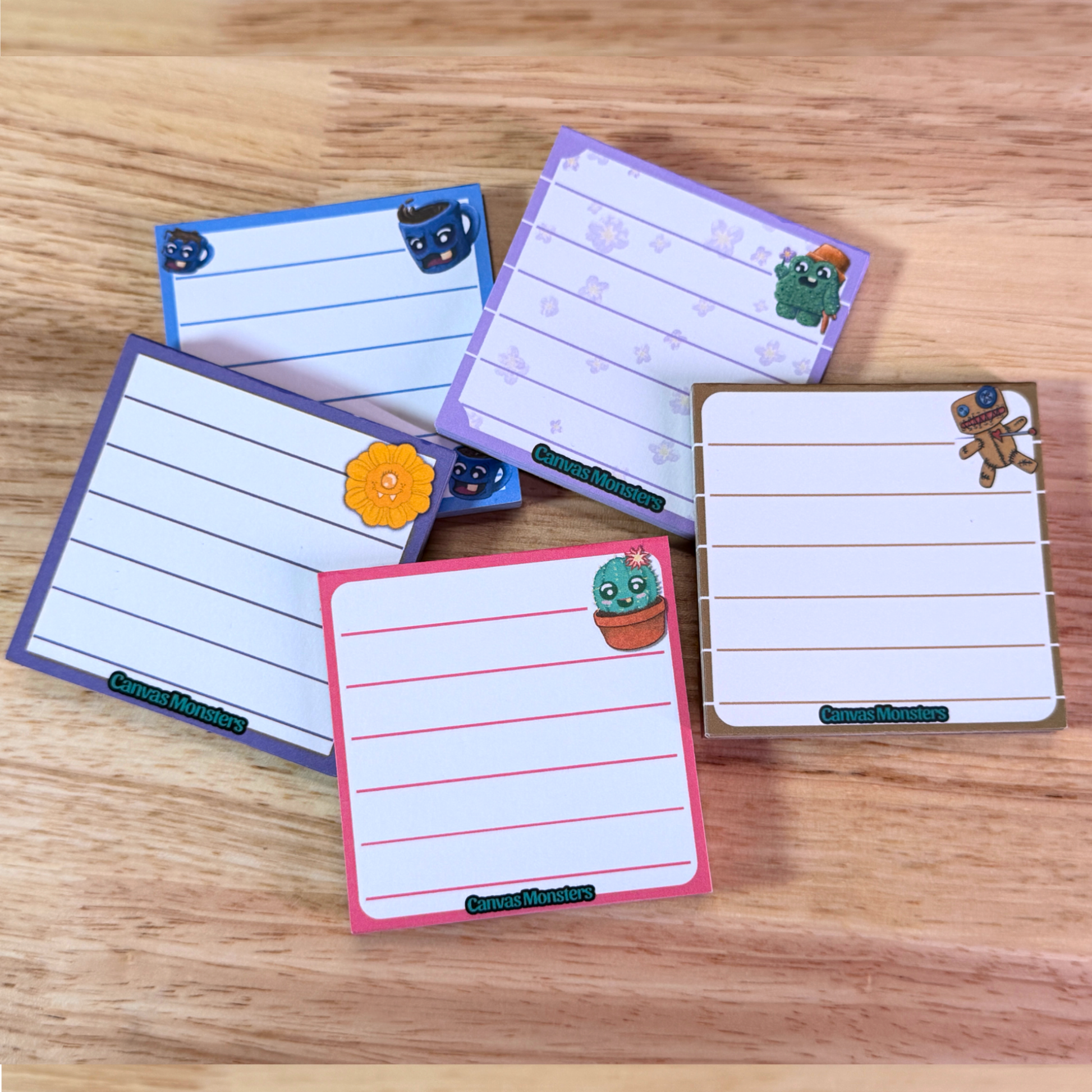 Set of colorful notepads with cartoon designs on a wooden surface