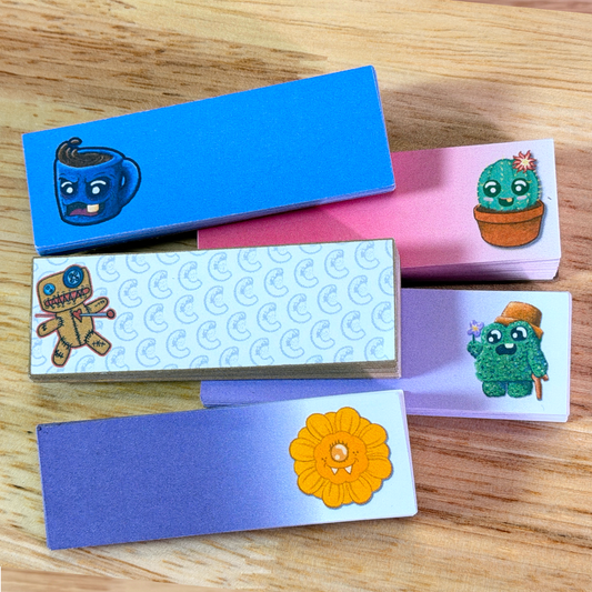 Set of colorful paper sticky notes with cartoon designs on a wooden surface