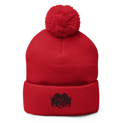 Image of a knit beanie with a pom pom on top, in solid red with a metal text logo on the front.