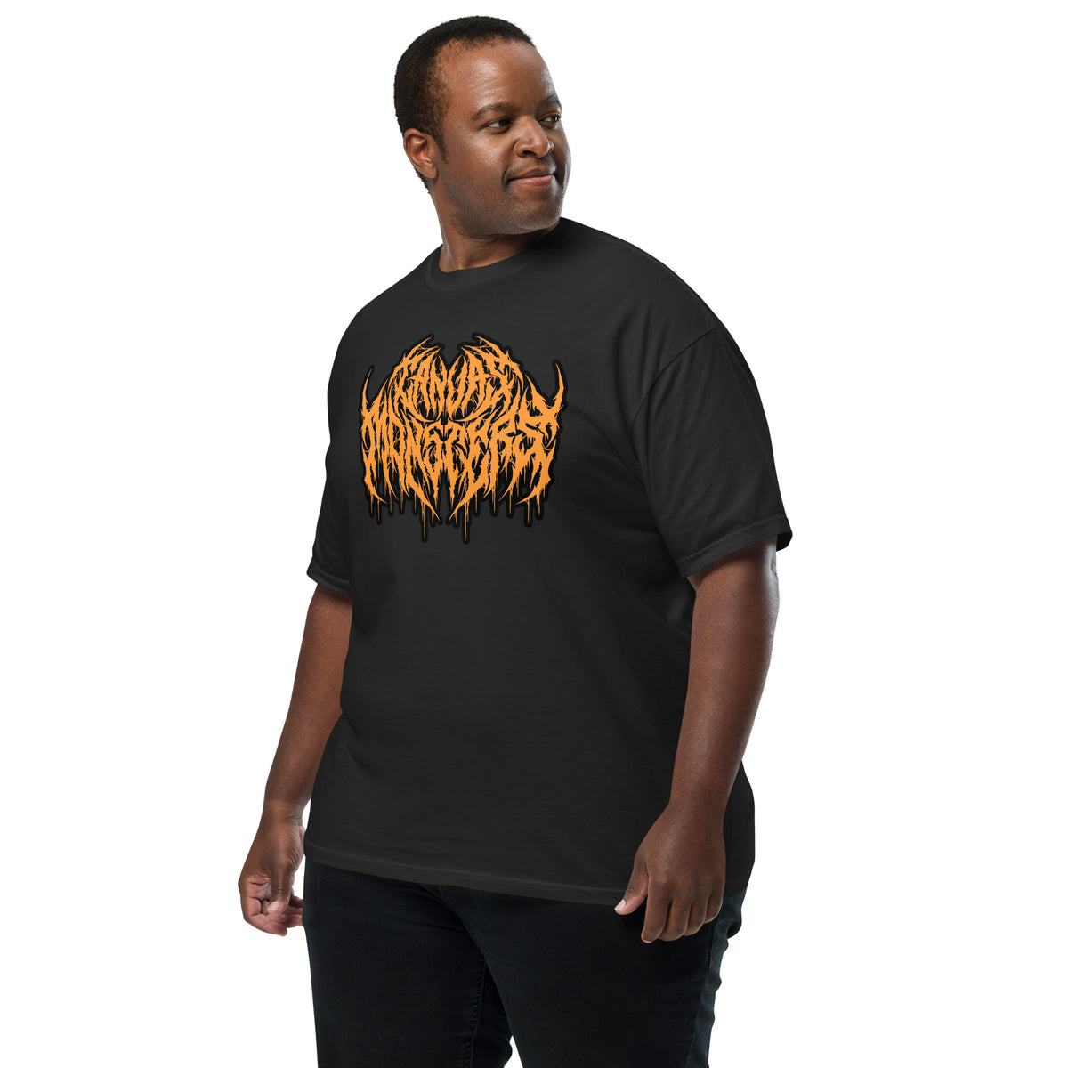 A man wearing a black short-sleeve t-shirt with a large orange and black stylized graphic on the chest, posed against a solid white background.
